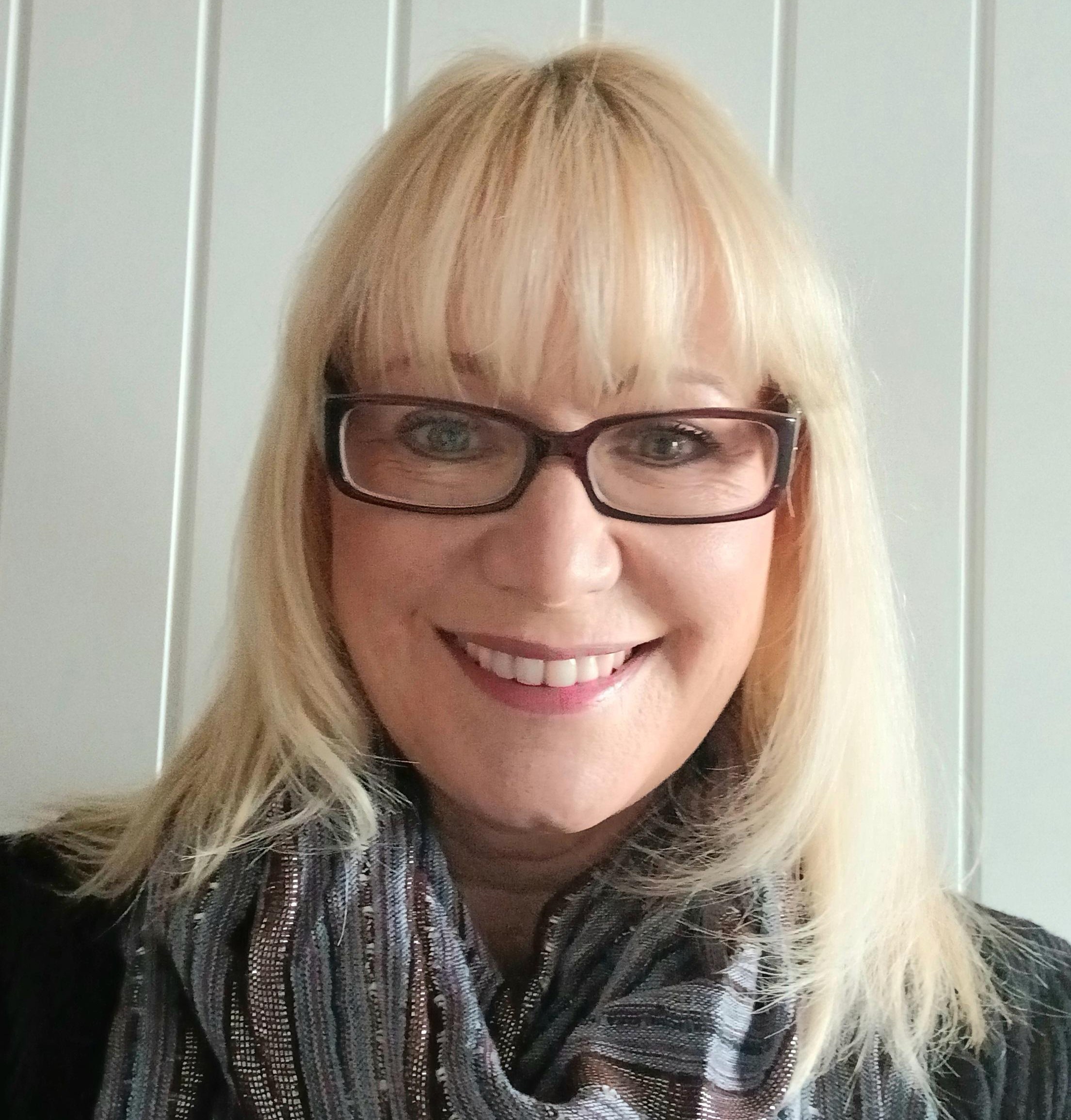 Woman with blonde hair against a white wooden background